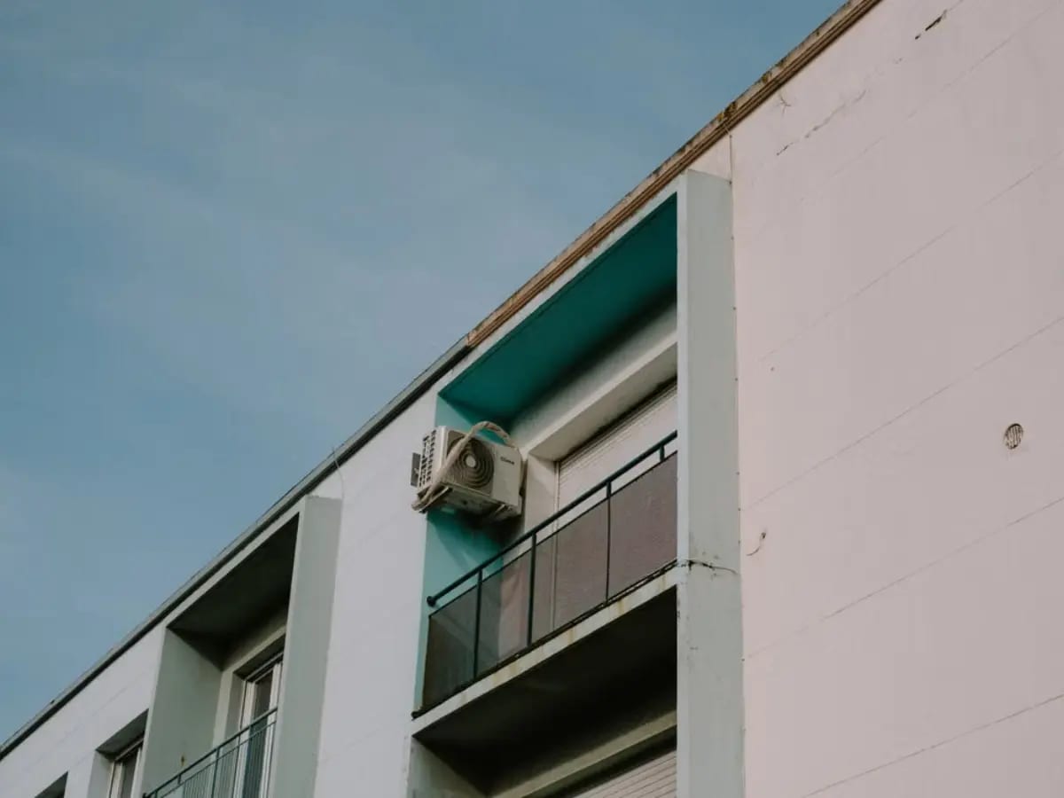Close up of an apartment building with external unit of an AC system.