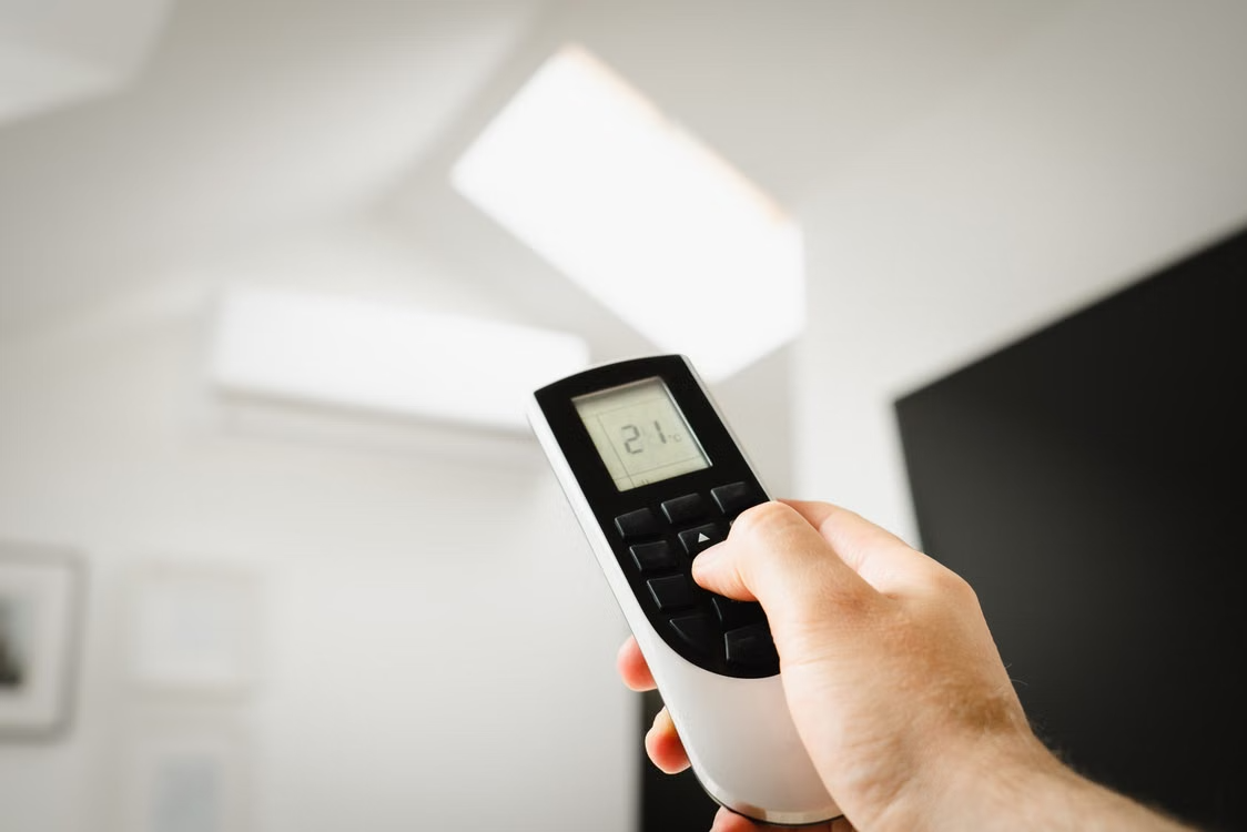 Man holding an AC remote